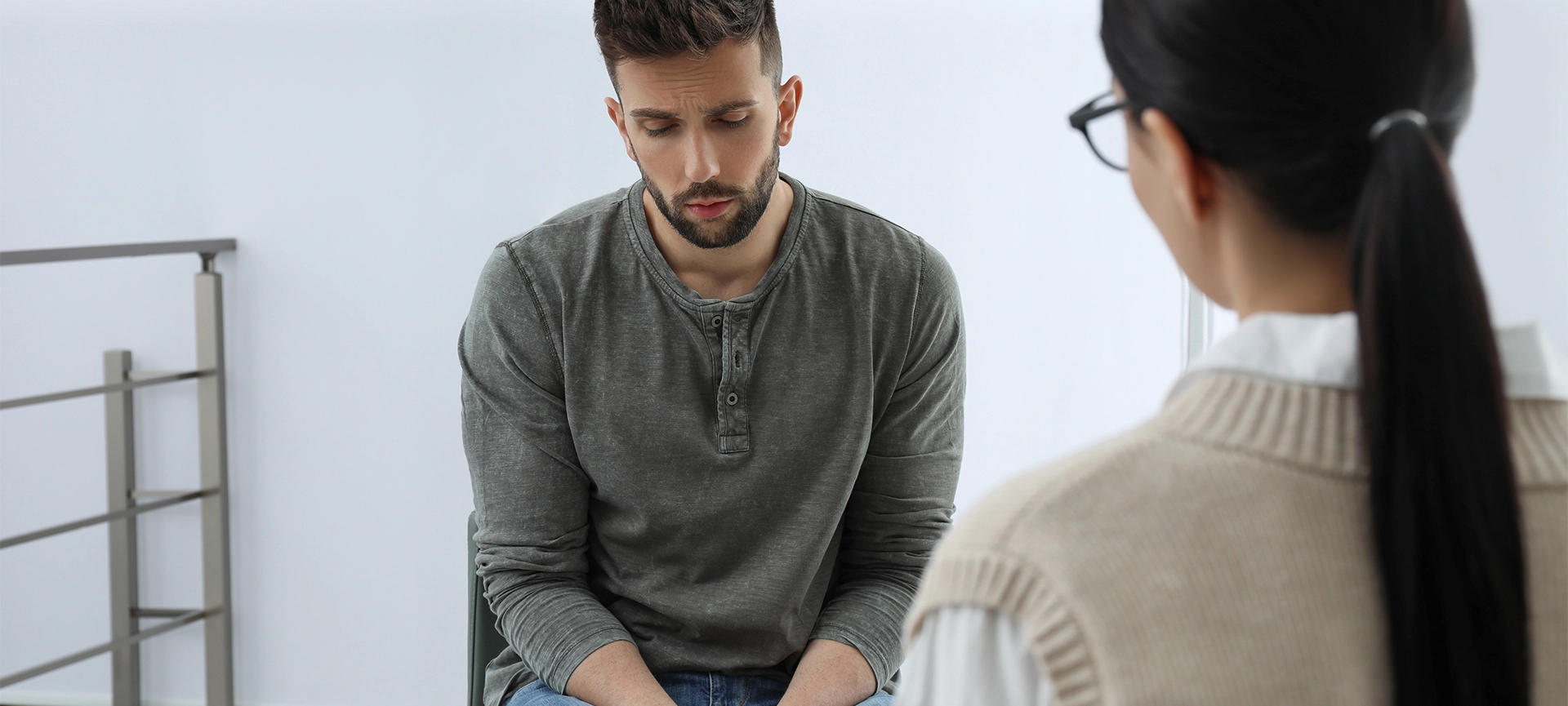 Psychotherapist working with drug addicted man indoors