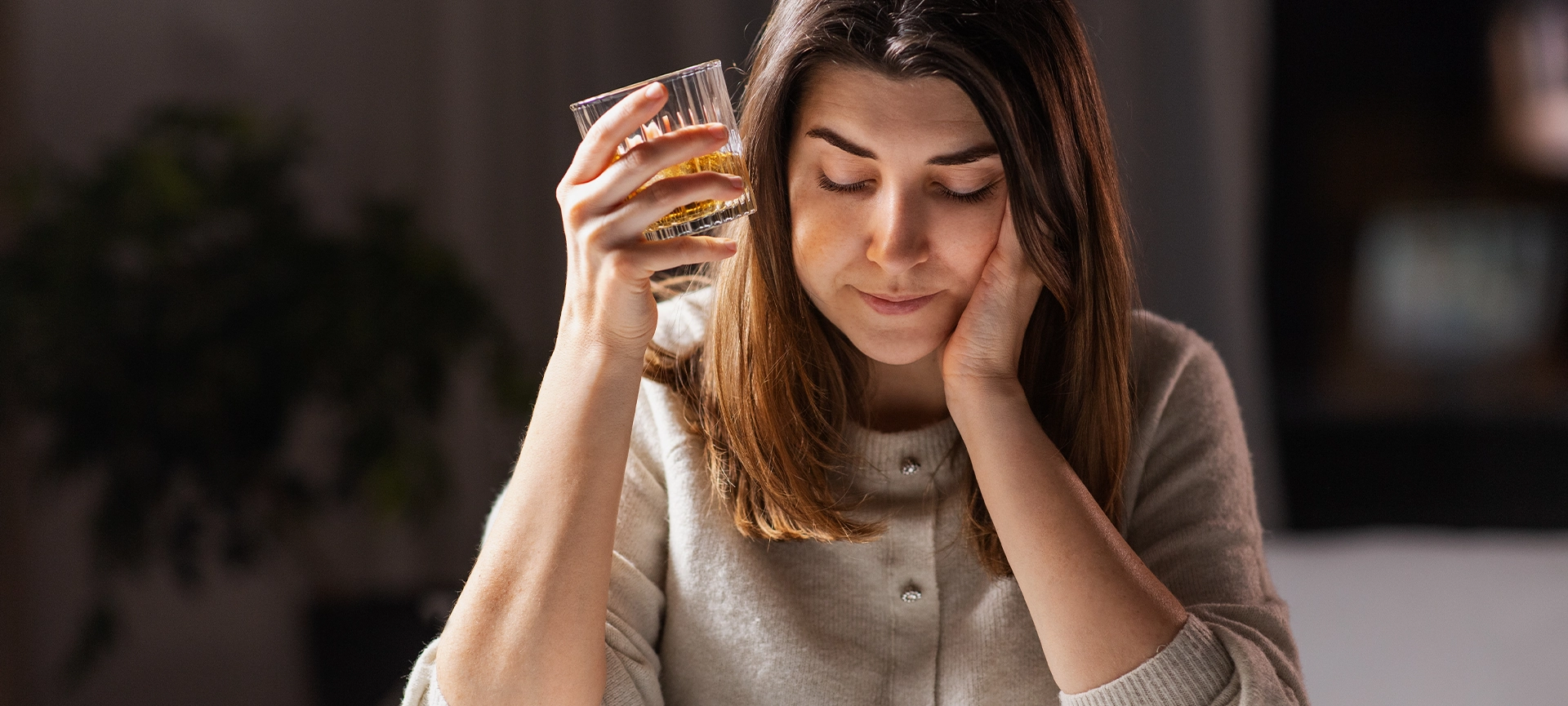 female alcoholic drinking whiskey at home