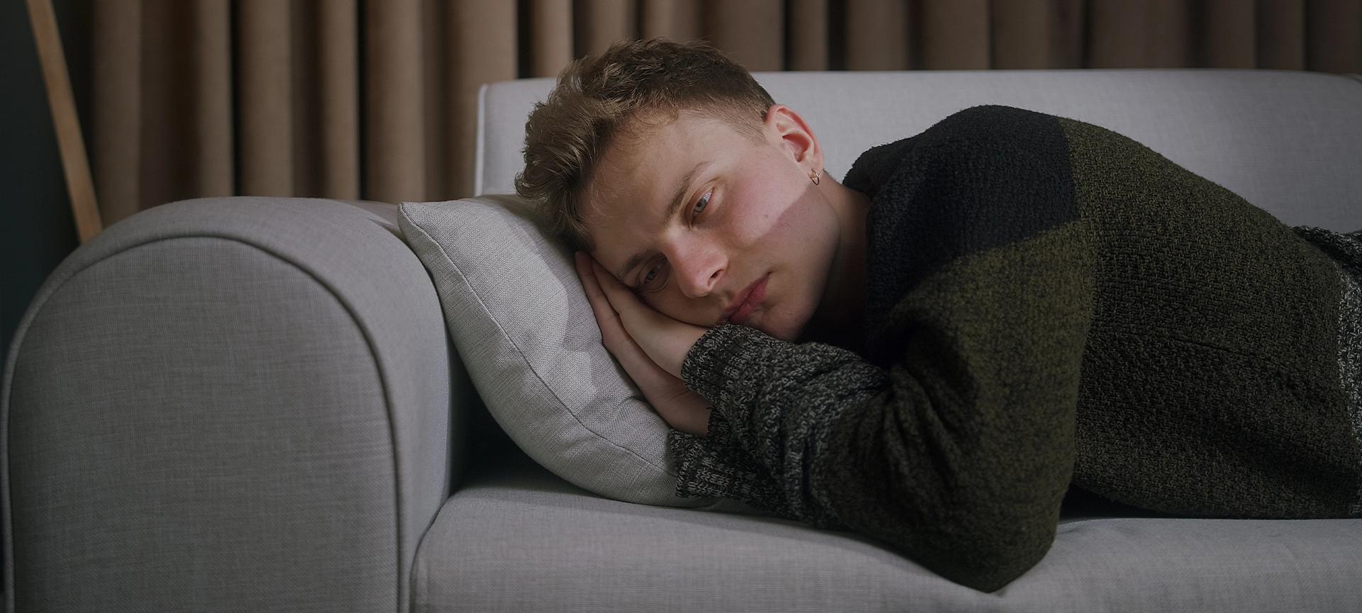 sleepy young man has trouble sleeping on the couch